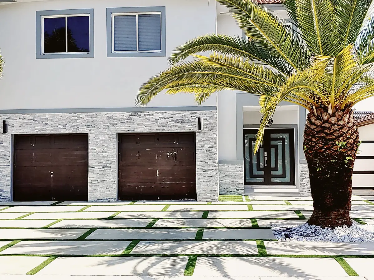 Concrete slab driveway with turf joints in front of a two-car garage