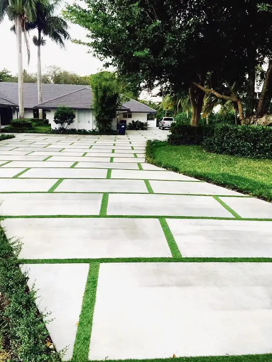 Long slab driveway through tropical landscaping