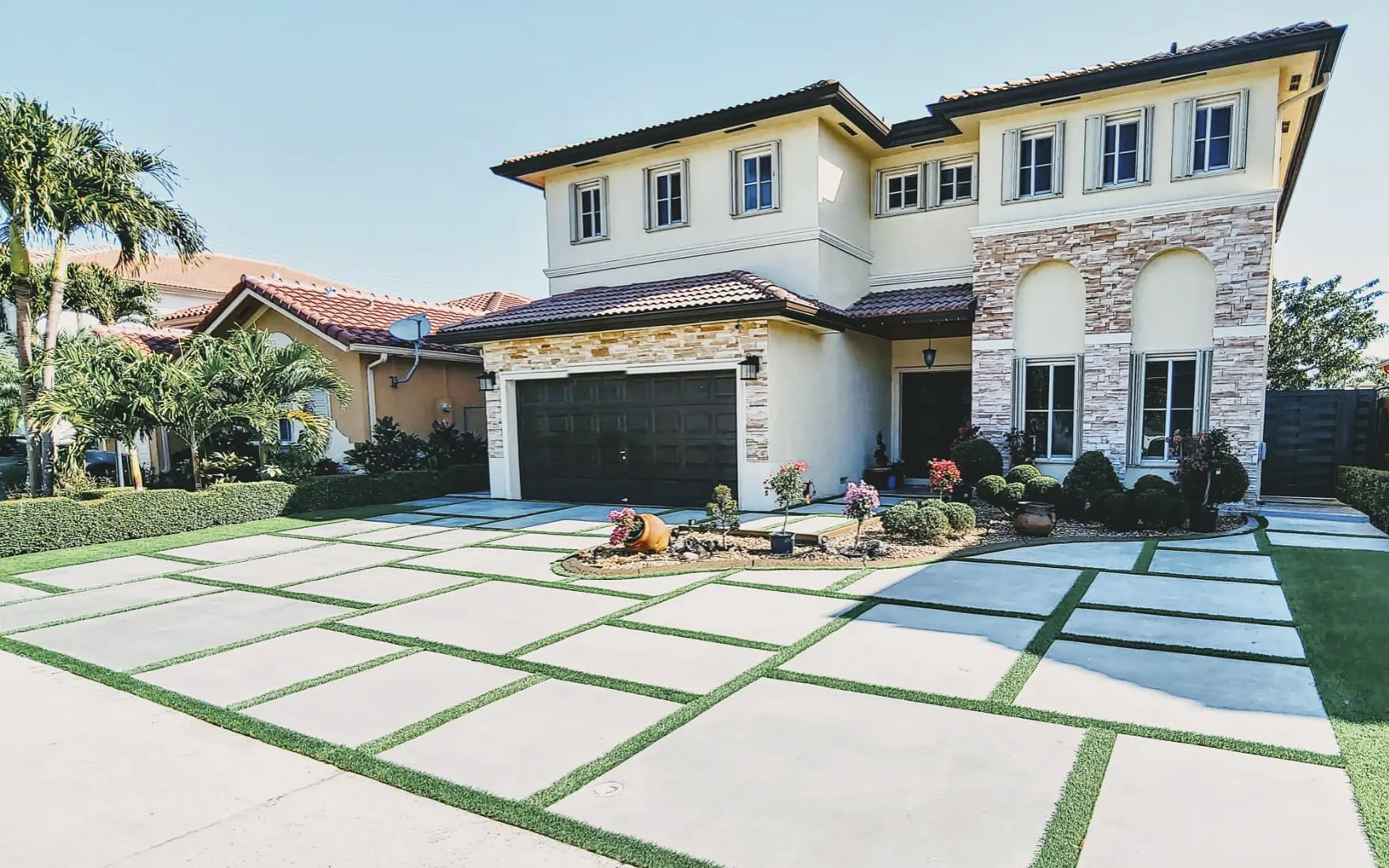 Concrete slab driveway with artificial turf joints at a South Florida home
