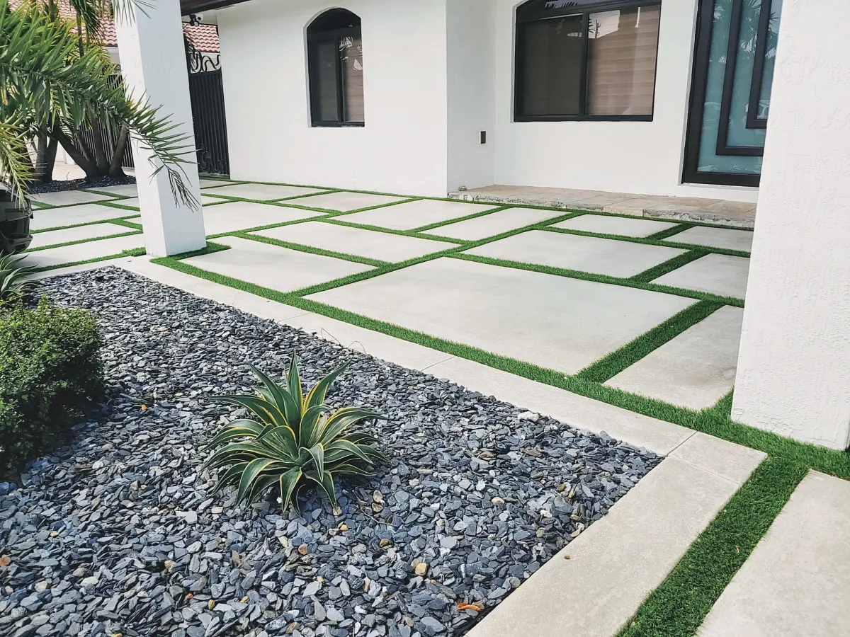 Front entry concrete slabs with turf joints next to a slate rock garden