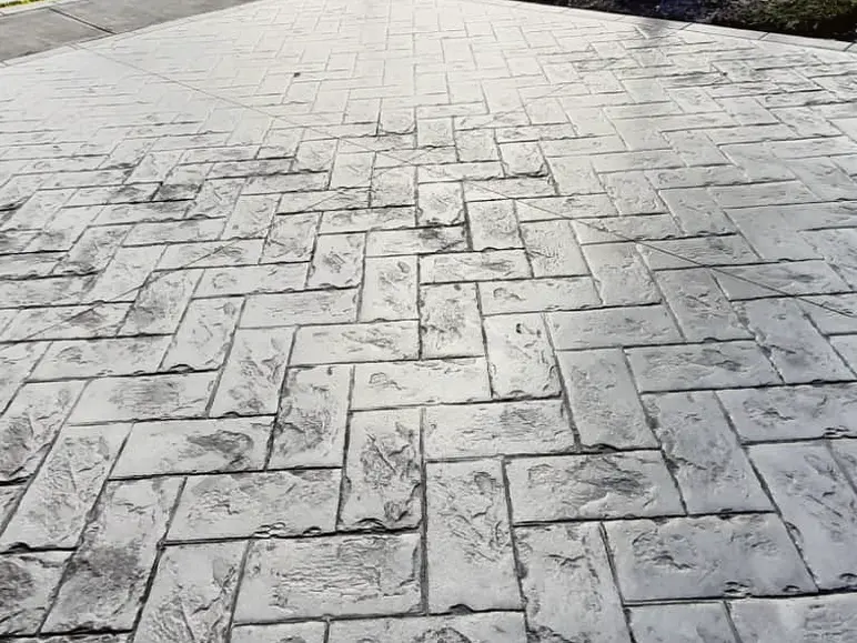 Grey stamped concrete driveway in a herringbone pattern