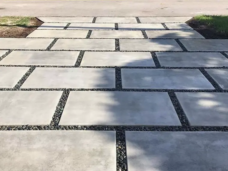 Concrete slab driveway with black river rock joints