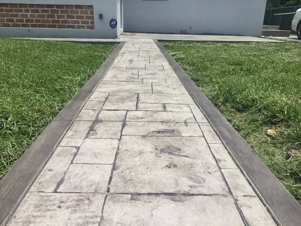 Stamped concrete walkway with an ashlar stone pattern and border