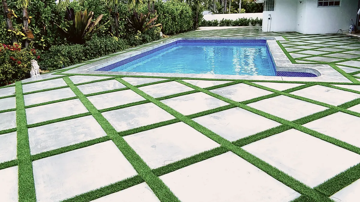 Pool deck of concrete slabs with turf joints